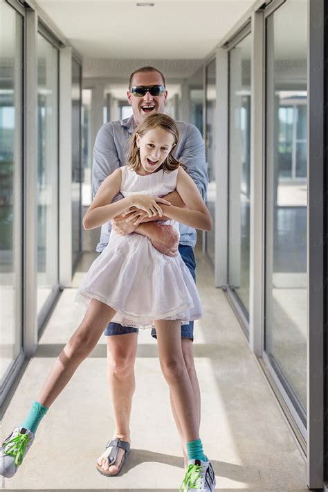 Father And Daughter Laughing In A Hallway Of A Modern Home Del
