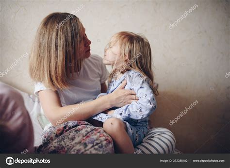 mama esta abrazando hija cama pijama manana familiar fotografia de
