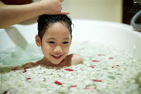 cute asian  girl bathing   bathtub full  petals