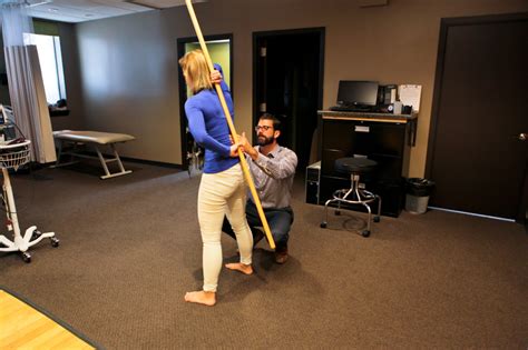 chiropractor helping woman use bar on back goodyear chiropractic