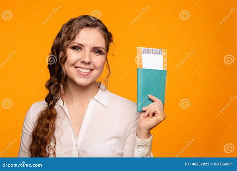 portrait of nice smiling woman holding passport and flying tickets