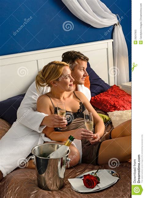 romantic couple cuddling bed champagne celebrating stock