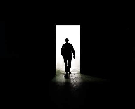 mysterious man walking  door   darkness  light stock