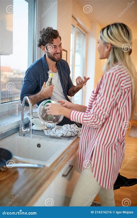 Caucasian Blonde Washing Dishes In Company Of A Young Beardy Guy Stock