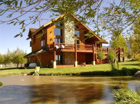 large house sitting  top   lush green field    river  front