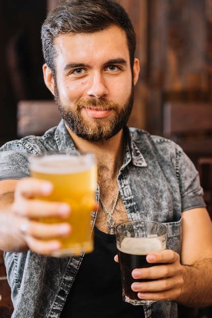 Free Photo Close Up Of A Man Holding Glasses Of Beer And Rum