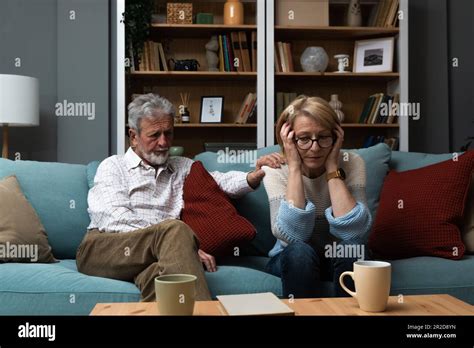 Sad Mature Woman Sitting Away From Her Husband After Having Quarrel