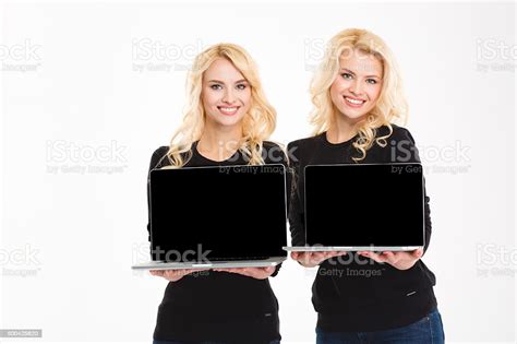 Cheerful Gorgeous Blonde Sister Twin Holding Blank Laptop Computer