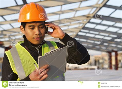 ingenieursbouw die mobiele telefoon spreken onder de nieuwe bouw stock afbeelding image