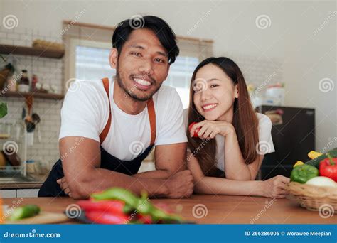 Portrait Of Young Asian Couple Making Salad Together At Home Cooking