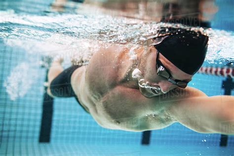 professional male swimmer practising  swimming pool underwater shot  young sportsman