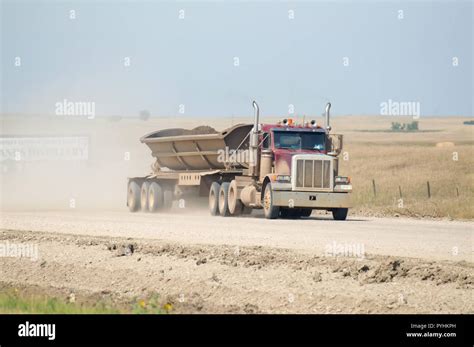 side dumping semi truck hauling dirt   dusty desert road stock