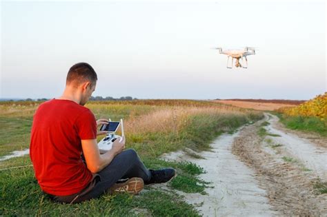 premium photo man flying  drone   green field young man navigating  flying drone