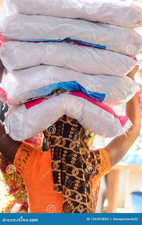 unidentified ghanaian woman carries plastic bags on her head at stock