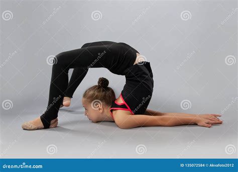 attractive girl gymnast performs a complex exercise flexibility