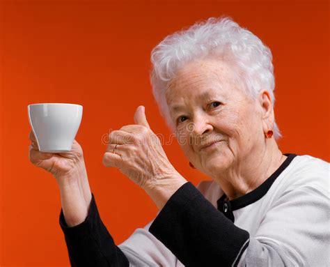 oude vrouw die  glazen koffie  thee van kop genieten stock afbeelding image
