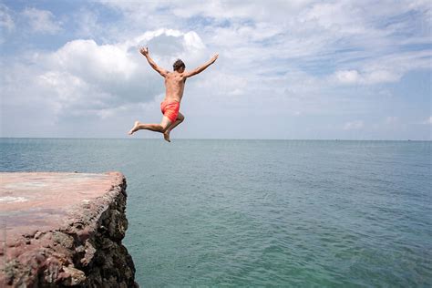 summer fun man jumping  cliff   ocean  jovo jovanovic