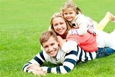 husband wife  child piled    stock image image  grass attractive