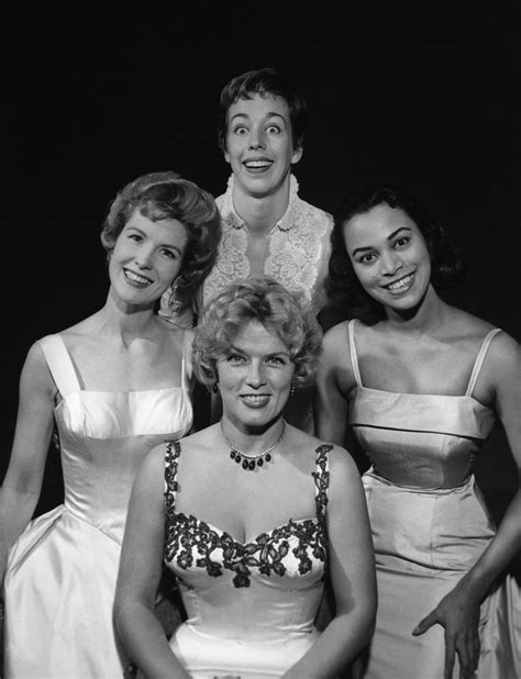 Three Women In Dresses Posing For A Photo With One Woman Wearing A