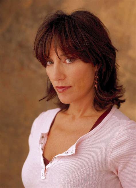 A Close Up Of A Person With Short Hair And Wearing A Pink Shirt