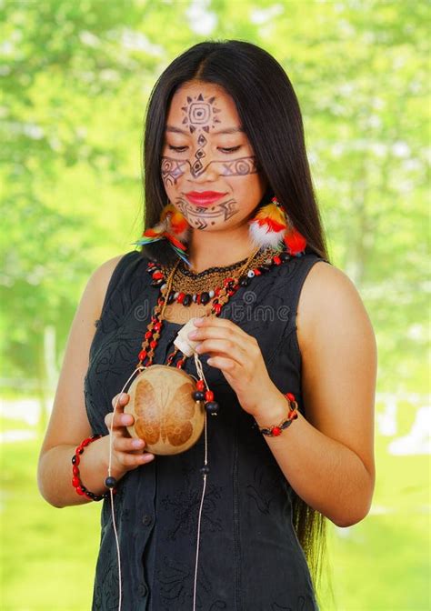 vrouw uit de amazone met gezichtsverf en het zwarte kleding stellen voor camera gekruiste