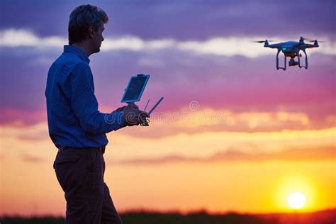 man operating  flying drone  sunset stock image image  high innovation