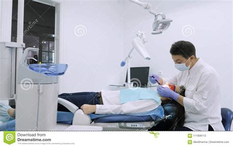 the dentist preparing patient for teeth whitening