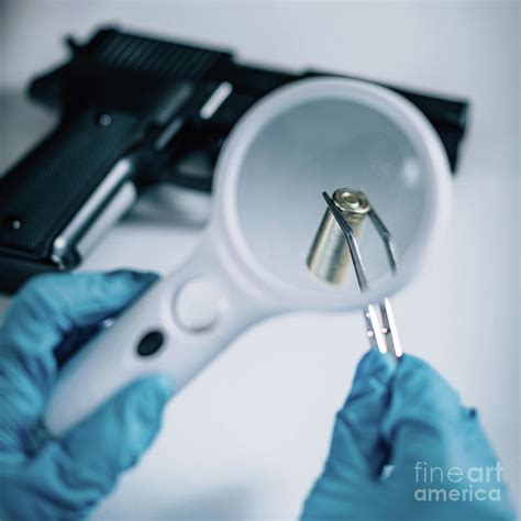 forensics expert examining crime scene evidence photograph by microgen