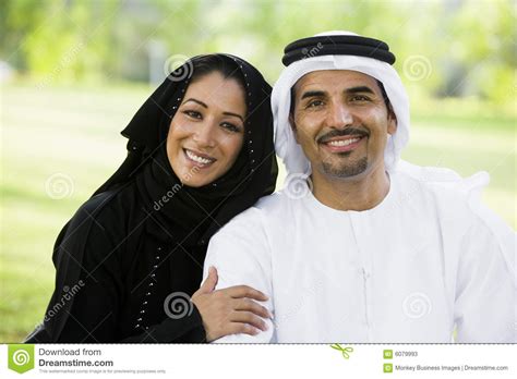 a middle eastern couple sitting in a park stock image