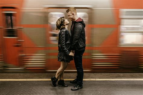 Photo Of Smiling Couple Standing On Train Station Platform While