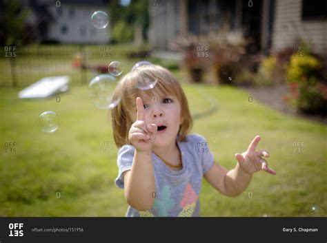 toddler popping soap bubbles stock photo offset
