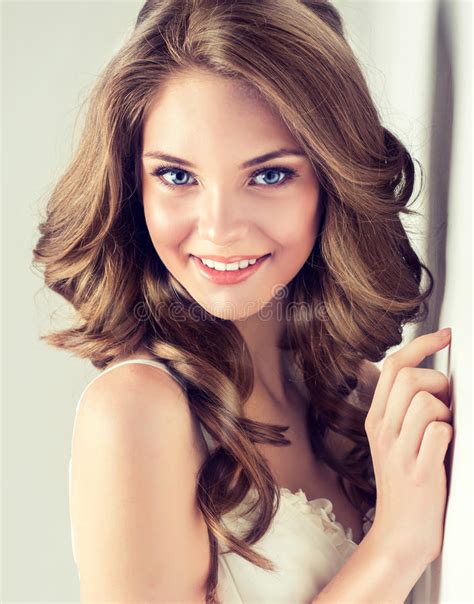 smiling beautiful girl brown hair with an elegant hairstyle hair waves curly stock image