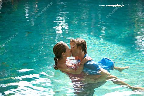 sexy junges paar in einem swimmingpool versunken während sie angezogen