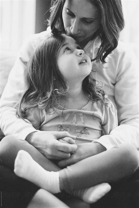 Mother Holding Her Daughter Sitting In A Chair By Stocksy Contributor