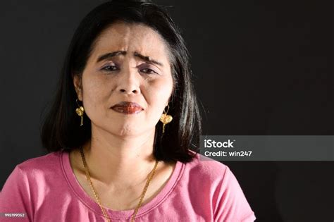 Sad Mature Adult Filipino Woman Closeup Against Black Background Stock