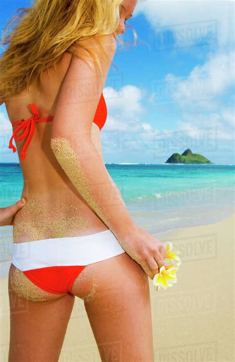hawaii oahu lanikai bikini clad girl on beach holding plumeria