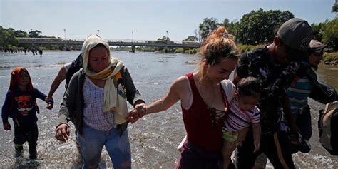 caravan migrants cross mexico river throw rocks at country s national