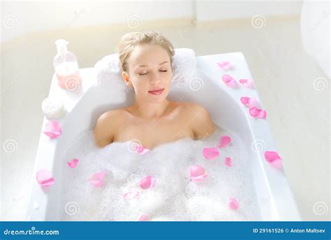 attractive girl relaxing in bath on light background royalty free stock