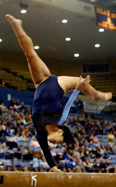 college gymnast with one hand on the balance beam
