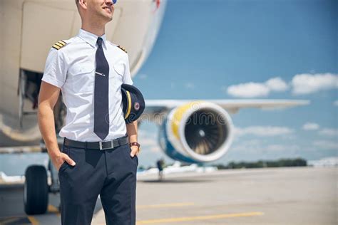 cheerful male pilot standing   plane  airport stock photo