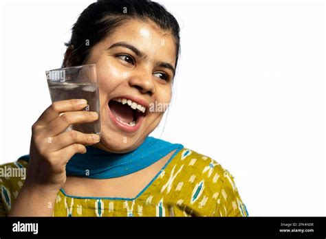 An Indian Asian Woman With A Glass Of Cold Water Touching On Her Cheek