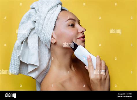 ultrasonic scrubber for facial skin cleansing girl in the bathroom
