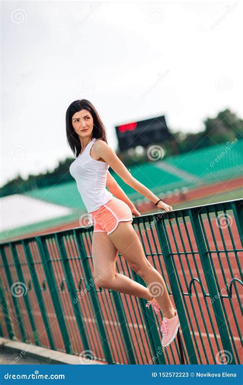 Beautiful Fitness Brunette Woman In In Pink Shorts And Tank Top Posing