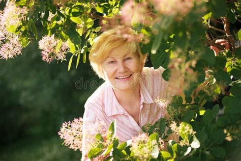 lively cheerful optimistic senior woman  flowers stock photo