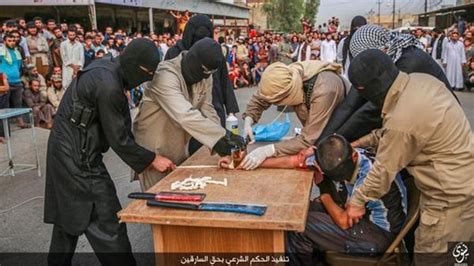 isis thugs chop of robber s hand in front of crowd of