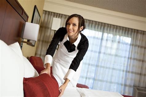 Happy Maid Making Bed In Hotel Room Housekeeping Service Cleaning
