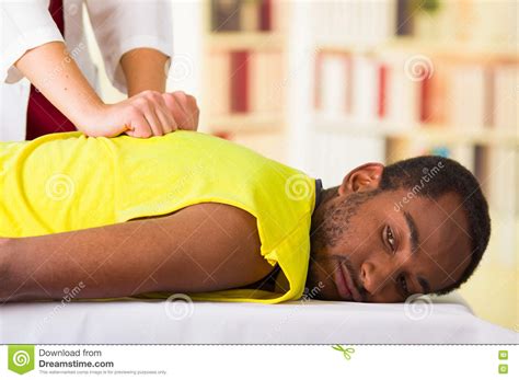 man getting physical treatment from physio therapist her hands working