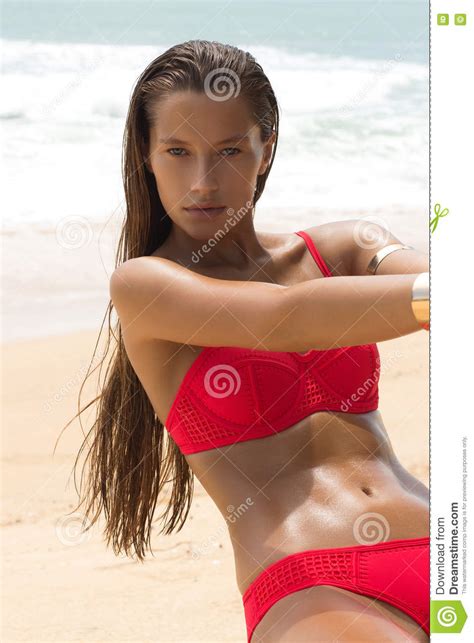 beautiful woman in sunglasses and red bikini on beach