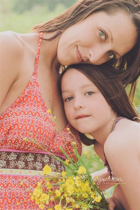 A Mother And Her Daughter Are Posing For A Photo In The Grass With
