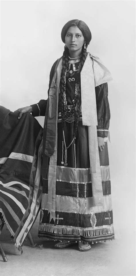 An Old Black And White Photo Of A Native American Woman With A Flag In